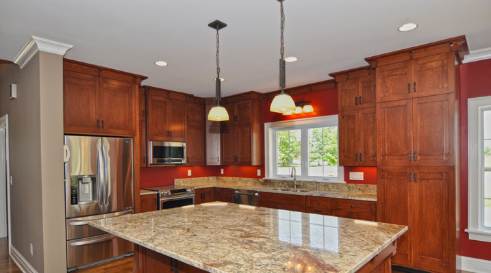 ICH Builders Mt. Sterling residence custom build kitchen view focusing on the galley island and it's stone countertop with craftsman style cabinets in background